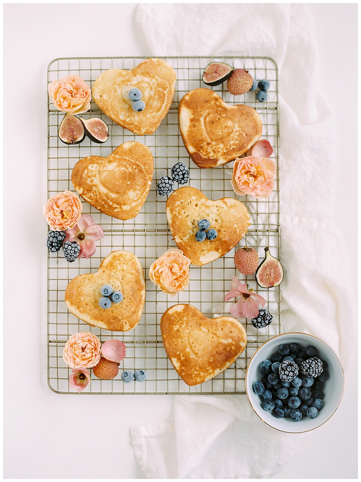 galentine's day ideas - pancakes shaped like hearts with flowers and blueberries